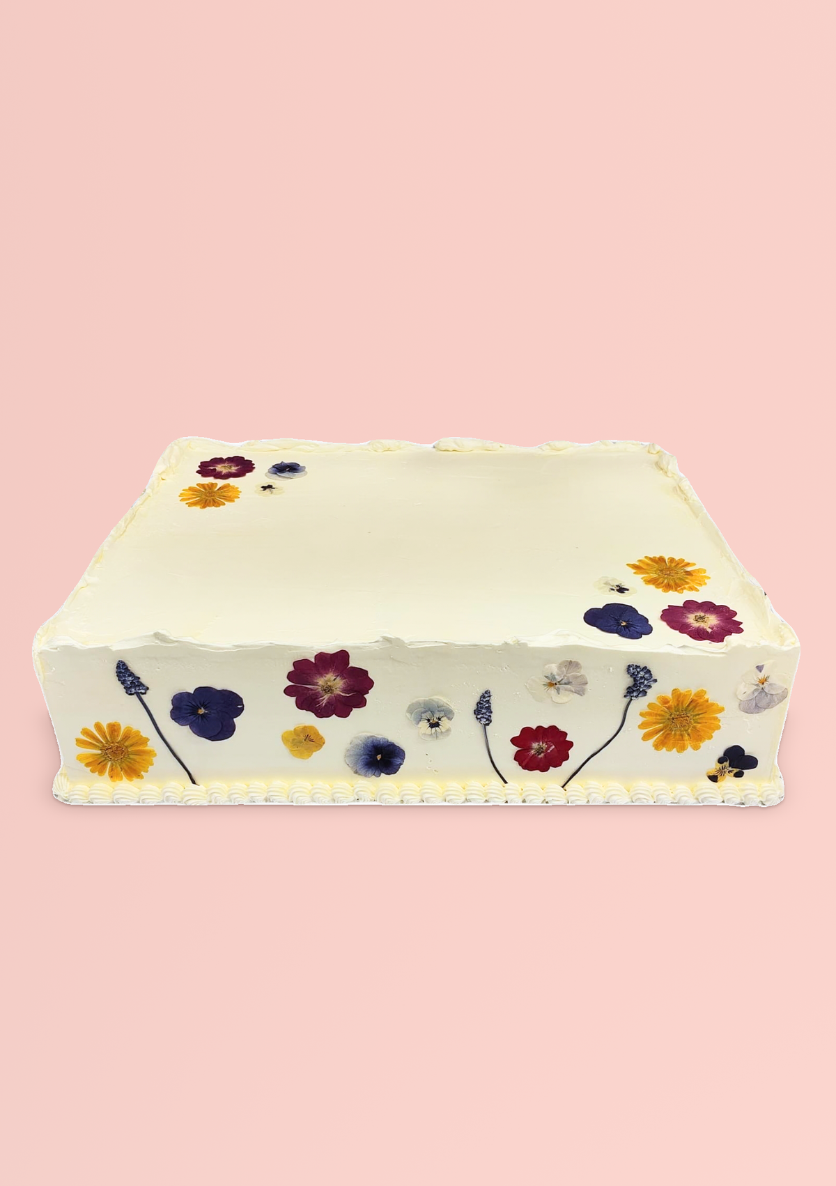 Rectangular white slab cake decorated with edible pressed flowers